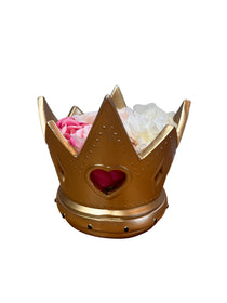 Gold crown-shaped vase with flowers on a wooden surface