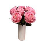 Bouquet of pink flowers on a wooden surface with a gray background