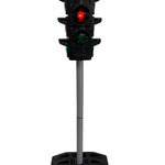 Miniature traffic light on a stand against a plain wall.