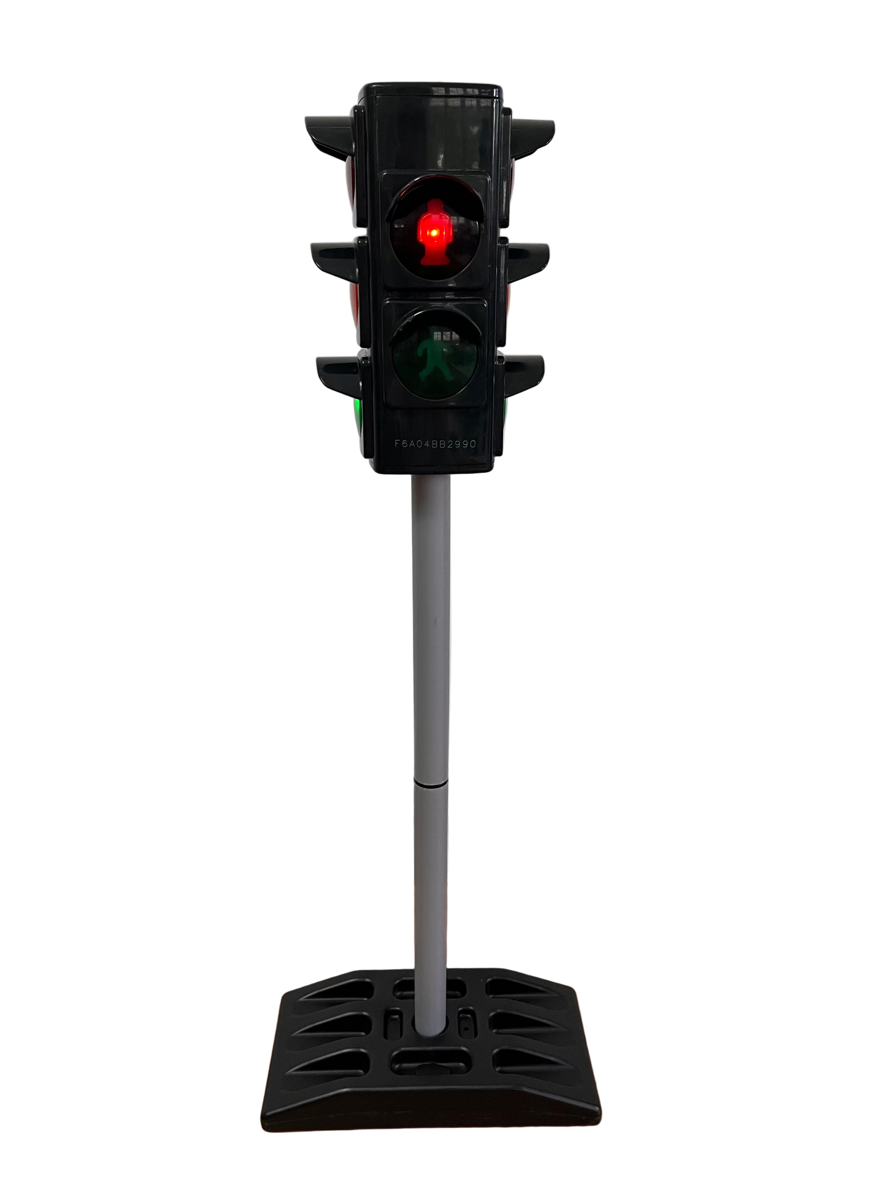 Miniature traffic light on a stand against a plain wall.