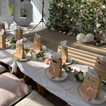 Decorated room with tables set for a celebration, floral wall, and large number '16'.