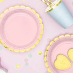 Pink and yellow children's plates with heart designs on a pink background