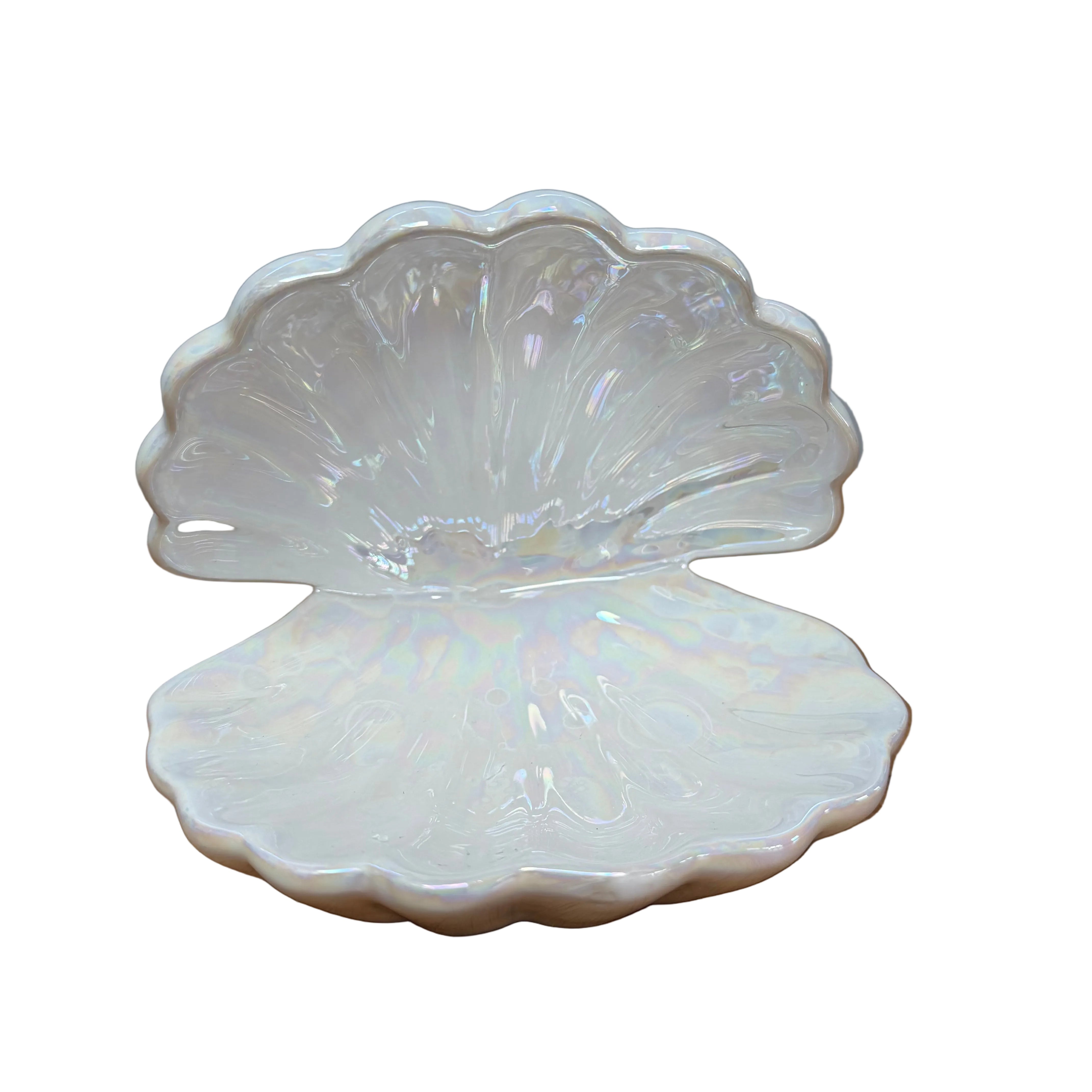 Iridescent shell-shaped dish on a wooden surface with a gray background