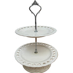 White decorative  cake stand with a metal stand on a wooden surface