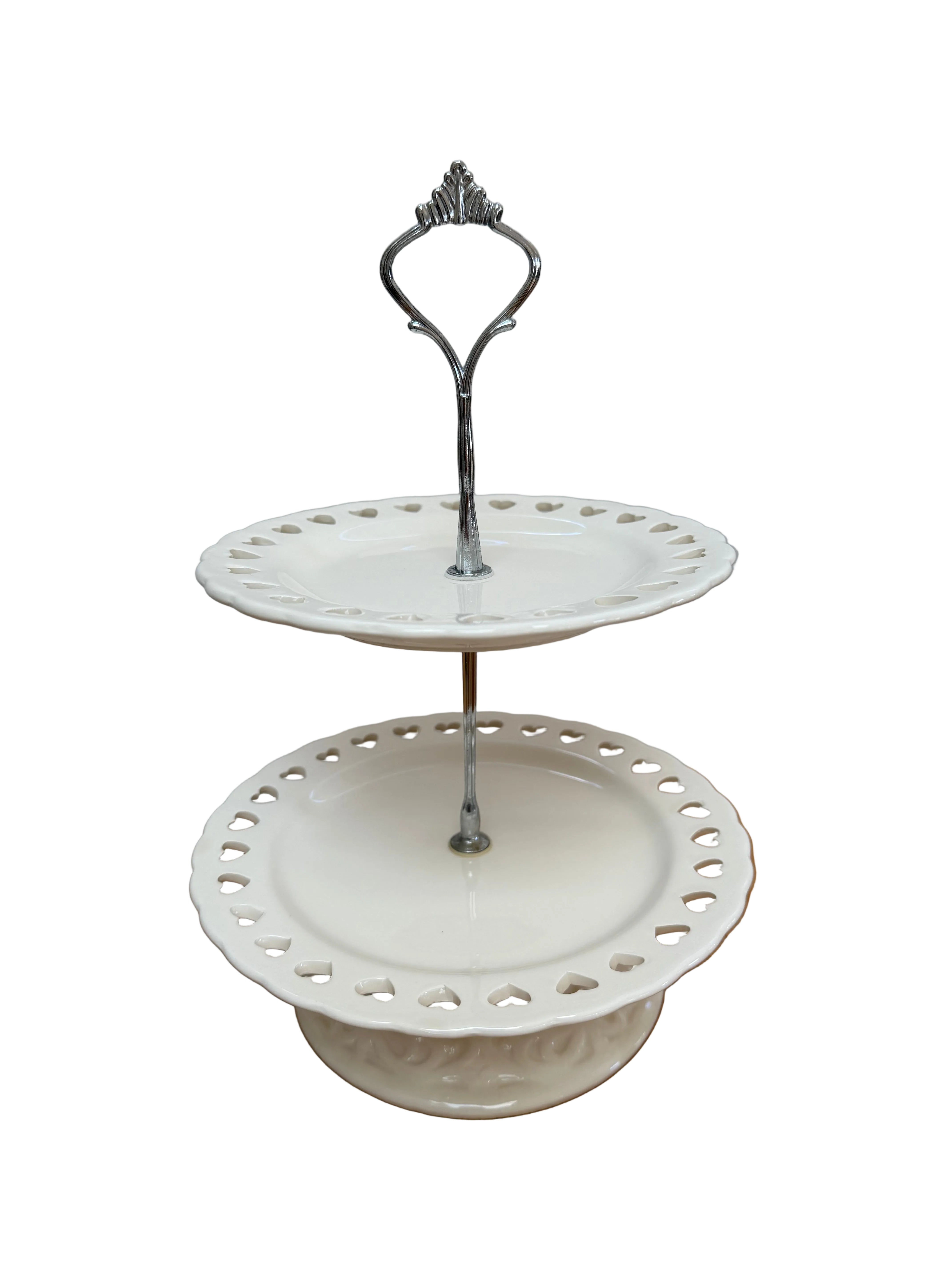 White decorative  cake stand with a metal stand on a wooden surface