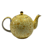 Yellow teapot with floral patterns on a white background